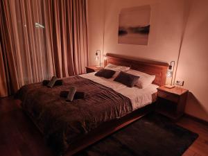 a bedroom with a bed with two slippers on it at Stylish wooden apartment with terrace in Pirin Golf Hotel&Spa Complex in Razlog