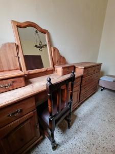 a wooden dresser with a mirror on top of it at EEM student Guest House (shared rooms) in Is-Swieqi