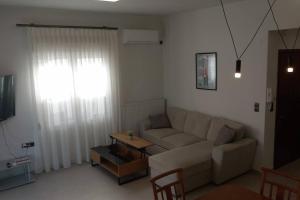 a living room with a couch and a table at Marika's Place in Néa Péramos