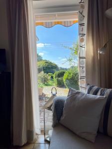 a couch in front of a window with a view at Reetdachhaus in Seenähe, Ruhige Lage, Kamin & Terrasse in Seedorf