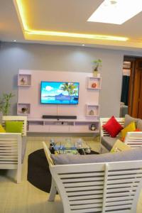 a living room with a television on a wall at The Hidden gem Near Acacia Mall, 2 BDRs in Kampala