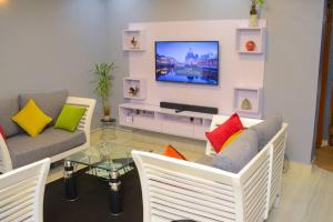 a living room with a couch and a tv at The Hidden gem Near Acacia Mall, 2 BDRs in Kampala
