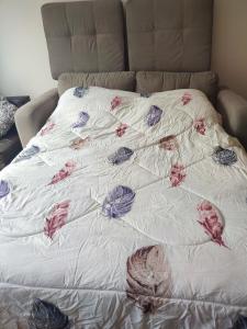 un letto con un piumone bianco e fiori sopra di Apartamento entero en el más importante centro financiero, bursátil, San Isidro, Lima, Peru a Lima