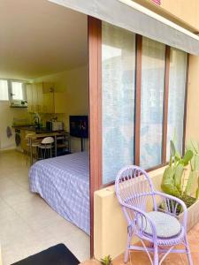 ein Schlafzimmer mit einem Bett und zwei Stühlen in einem Zimmer in der Unterkunft GOLDEN HOUR Studio Marittimo in Palma de Mallorca