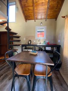 einen Tisch und Stühle in einer Küche mit Spüle in der Unterkunft Hostel El Paredon in El Chalten