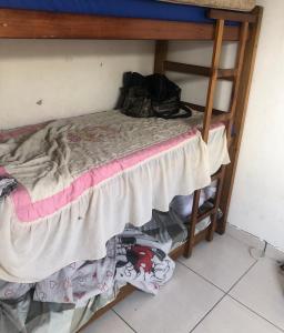 a bunk bed in a room with clothes under it at House DayDrigo in Búzios