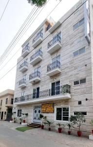 a large building with balconies on the side of it at Hotel Grand Pakeeza in Lahore