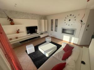 a living room with a white couch and a clock at HOUSE 58 in Montaner