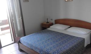 モシャーノ・サンタンジェロにあるEremo dei Poetiのベッドルーム1室(青い掛け布団付きのベッド1台付)