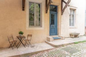 une maison avec une porte bleue et deux chaises dans l'établissement La chouette d'or, à Dijon