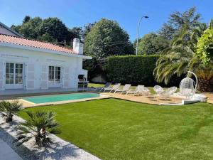a backyard with chairs and a swimming pool at Villa standing Biarritz in Biarritz