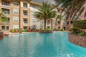 una gran piscina frente a un edificio en Cozy Oasis Pool Gym Wi-Fi Pets OK Near NRG en Houston