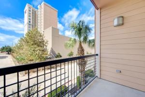 a balcony with a fence and a palm tree at Cozy Oasis Pool Gym Wi-Fi Pets OK Near NRG in Houston