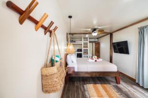 a bedroom with a swinging bed and a tv at Ocean Tide Beach Resort in San Pedro