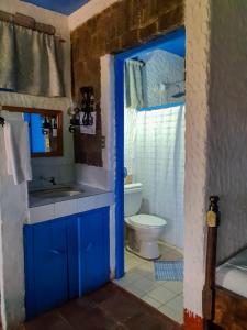 Baño azul con lavabo y aseo en Eco Hotel Uxlabil Atitlan, en San Juan La Laguna