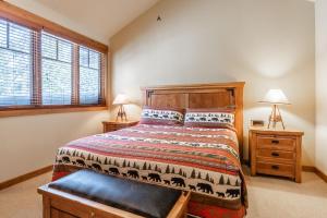 Un dormitorio con una cama y dos lámparas y una ventana. en Upscale 4 Bed, 3 Bath at the Woodwinds with Amazing Mountain Views and Golf Course Access and private hot tub and garage sleeps 10, en Mammoth Lakes