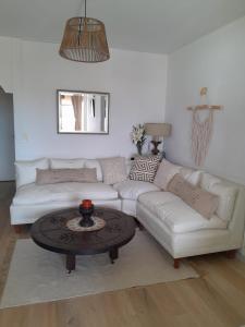 a living room with a white couch and a table at Departamento 1 dormitorio con vista a la Isla Gorriti in Punta del Este