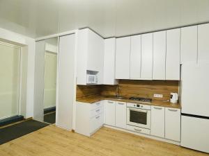  La cuisine est équipée de placards blancs et d'un réfrigérateur. dans l'établissement На Куліша 3, сучасні апартаменти біля оперного, à Lviv