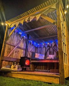 a dog laying on a bed in a wooden house at North Yorkshire Horse Box in York