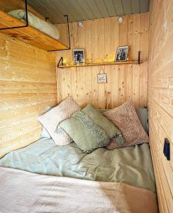 uma cama no canto de um quarto com paredes de madeira em North Yorkshire Horse Box em York