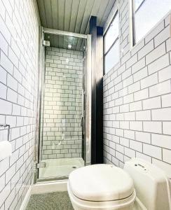 uma casa de banho branca com um WC e um chuveiro em North Yorkshire Horse Box em York