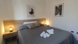 a bedroom with a bed with two white towels on it at LechicchediLampedusa in Lampedusa