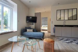 孔卡尔诺La Maison de Tante Yvonne - Gîte de Kerblaise的客厅里有一张沙发和一张桌子。