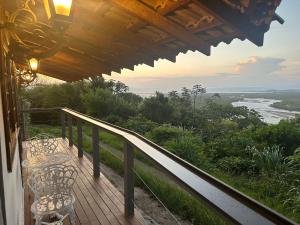 a balcony with a table and chairs and a view of a river at Minas Em Marambaia in Rio de Janeiro
