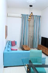 sala de estar con sofá azul y TV en Appartement Haut standing S+3 - plein centre ville, en Túnez