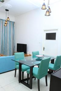 a dining room with a table and green chairs at Appartement Haut standing S+3 - plein centre ville in Tunis