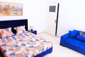 a bedroom with a bed and a blue couch at Appartement Haut standing S+3 - plein centre ville in Tunis