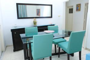 ein Esszimmer mit einem Glastisch und blauen Stühlen in der Unterkunft Appartement Haut standing S+3 - plein centre ville in Tunis