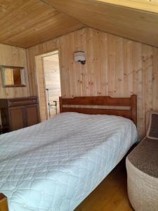 1 dormitorio con 1 cama en una habitación con paredes de madera en Будинок в пейзажній місцевості, en Krivorovnya