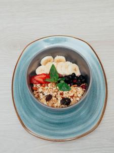 a bowl of food with bananas and berries on a plate at The Point Miraflores - Party Hostel in Lima