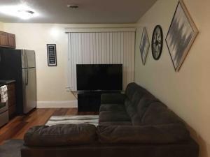 a living room with a couch and a flat screen tv at The luxury lounge in Schenectady
