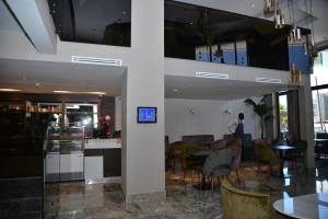 una hall con tavoli e sedie e una persona in una stanza di Privilège Oasis Hôtel a Casablanca