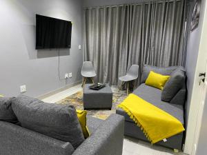 a living room with a couch and a tv at Ongwe Complex - Holiday Apartment in Swakopmund