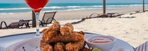 a plate of food on a table at the beach at Dom Pedro Laguna Beach Resort & Golf in Fortaleza