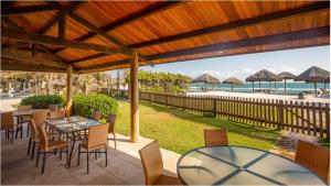 un patio con tavoli e sedie e vista sulla spiaggia di Dom Pedro Laguna Beach Resort & Golf a Fortaleza