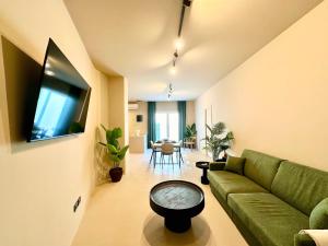 sala de estar con sofá verde y mesa en CARBONE XXI, en Catania