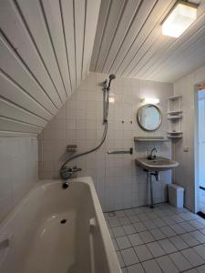 y baño con bañera y lavamanos. en Het Familie Boshuisje - vakantiewoning op prachtig park met veel faciliteiten inc ligbad, en Gramsbergen