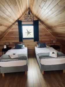 a bedroom with two beds in a wooden cabin at sKLONowane domki pod Czarną Górą in Bystrzyca Kłodzka