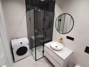 ein Badezimmer mit einer Waschmaschine und einem Spiegel in der Unterkunft Tina Apartment N64 in Agaraki