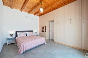 a bedroom with a bed and a wooden ceiling at Poseidon House in Pollonia