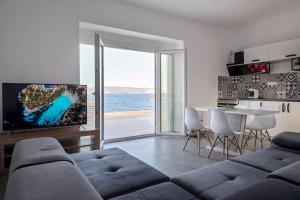 a living room with a couch and a table with a television at Poseidon House in Pollonia