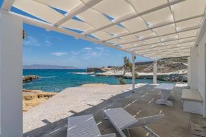 a white patio with chairs and a view of the ocean at Poseidon House in Pollonia