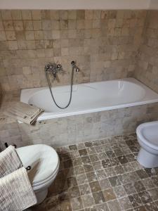 a bathroom with a bath tub and a toilet at LA VILLA APARTMENTS - Convenient for Sardinia and Corsica - 5 beds -Private Parking included with Camera in Livorno