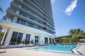 a hotel with a swimming pool in front of a building at Amazing looking studio 5 min from Ocean near Aventura Mall and Gulfstream casino SPECIAL PROMO INSIDE in Hallandale Beach