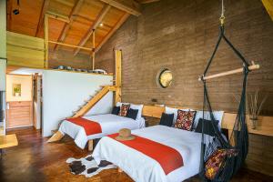 een slaapkamer met 2 bedden en een hangmat bij Hotel El Remanso Tapalpa in Tapalpa