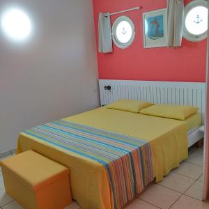 a bedroom with two beds and two windows at Appartement Colibri de la Baie de Tartane in La Trinité